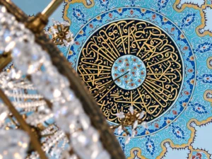 Turquoise and gold ceiling medallion seen past a crystal chandelier